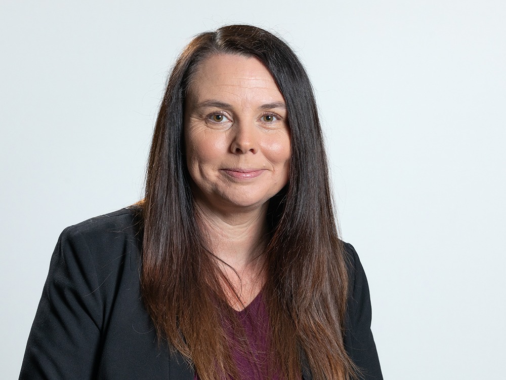 Marie Wilcox in a black jacket and purple top