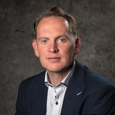 Simon Wilcox in a navy blazer and white shirt
